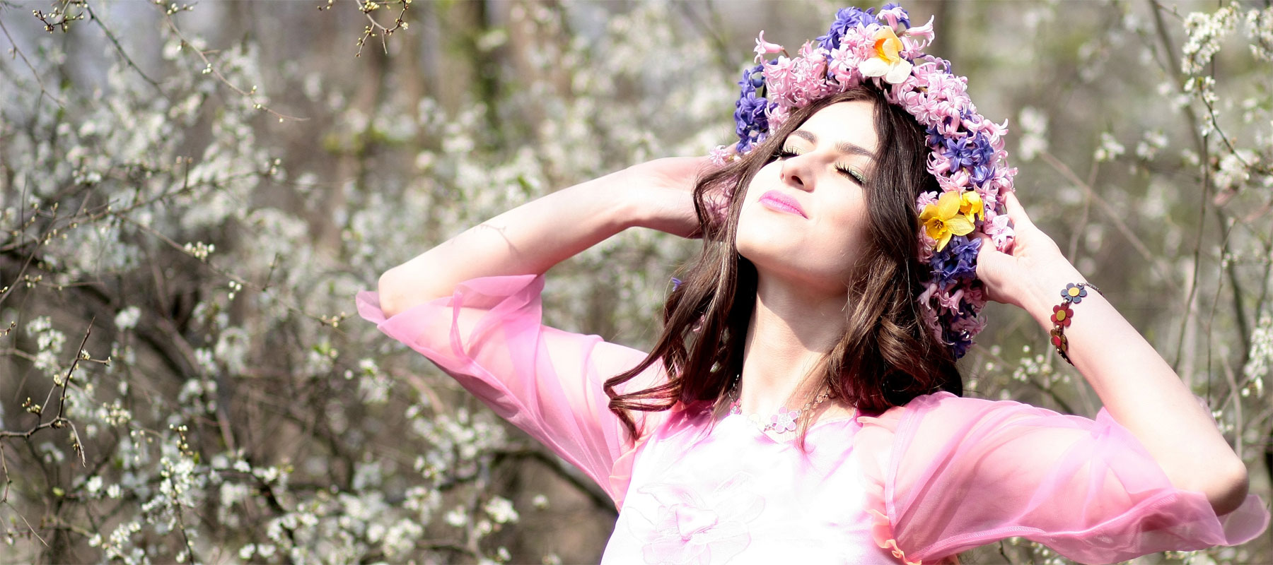Image of success. Photo of quirky, flower-child woman with face raised to sunshine, expression of peace and happiness.